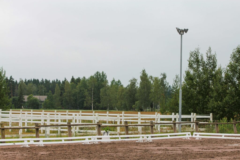 Arena demarcated with a low guard with a post and rail fence further on the outside 